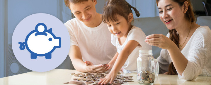Parents teaching daughter how to save money by placing coins in mason jar.