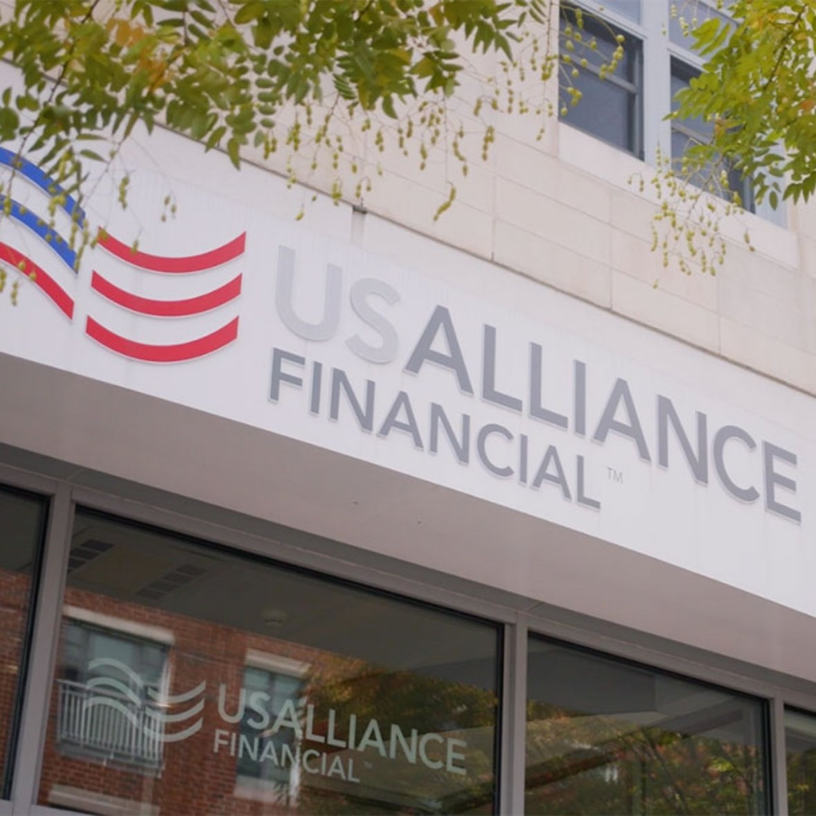 USALLIANCE Financial sign on the exterior of a building with glass windows below.